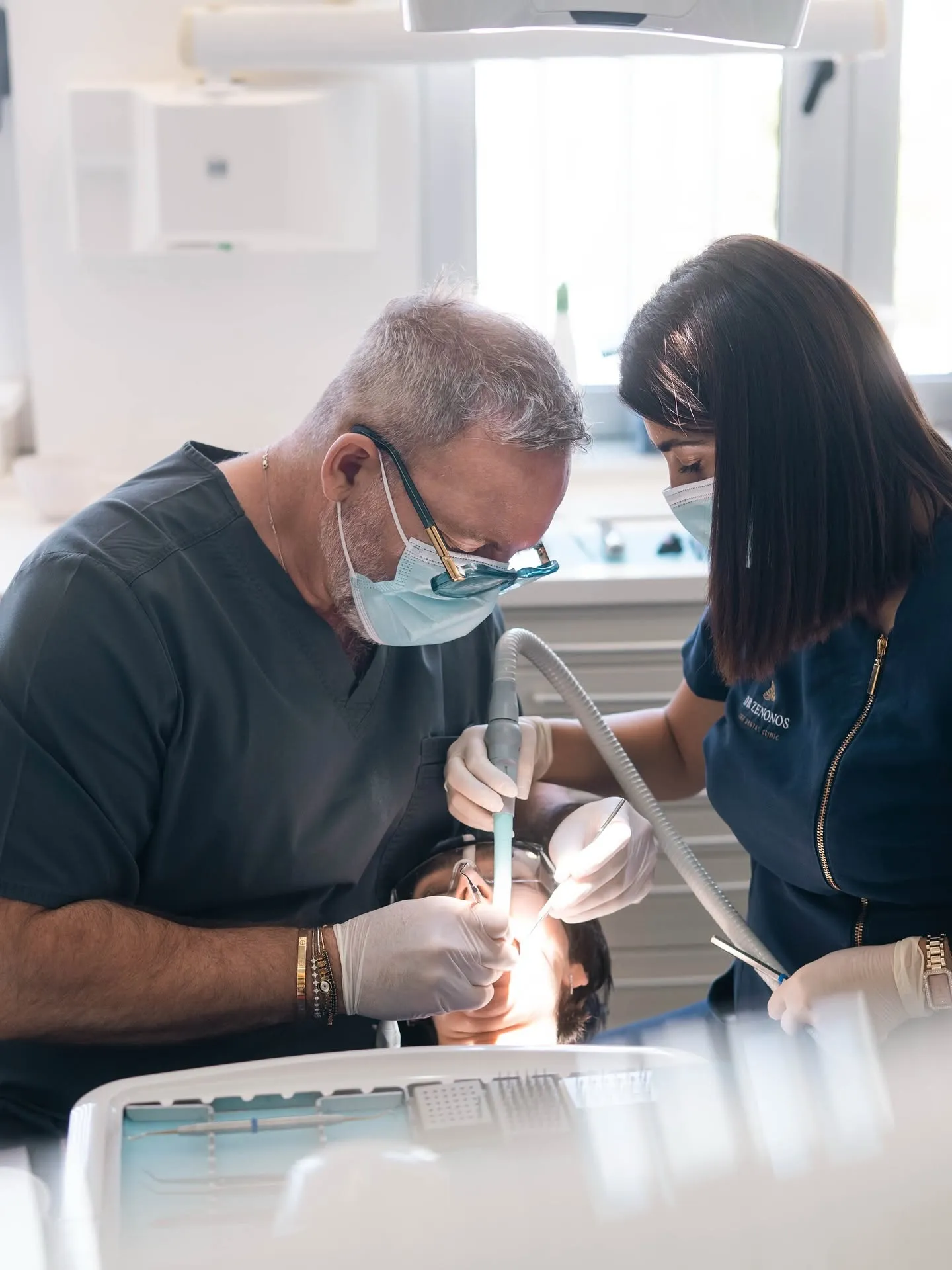 Dr Zenonos treating a patient with his assistant